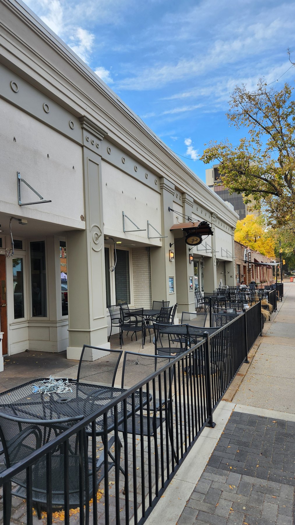 Jay’s Bistro patio façade after blue fabric awnings were removed, with metal brackets remaining.